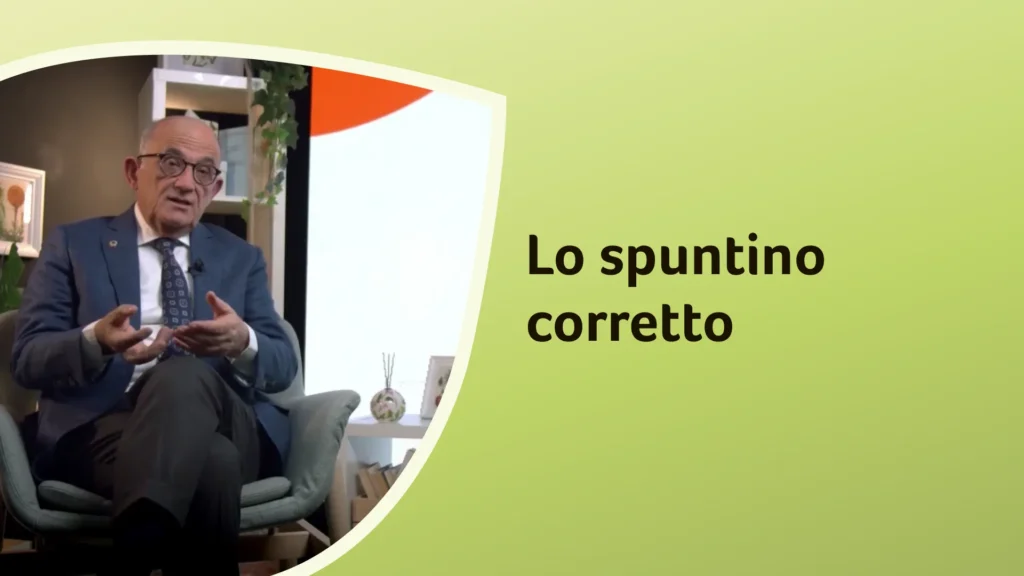 Il dottor Rossi seduto con le gambe accavallate, gesticola durante la spiegazione sull’importanza dello spuntino. Sullo sfondo è riportato il titolo dell'episodio: “Lo spuntino corretto”.