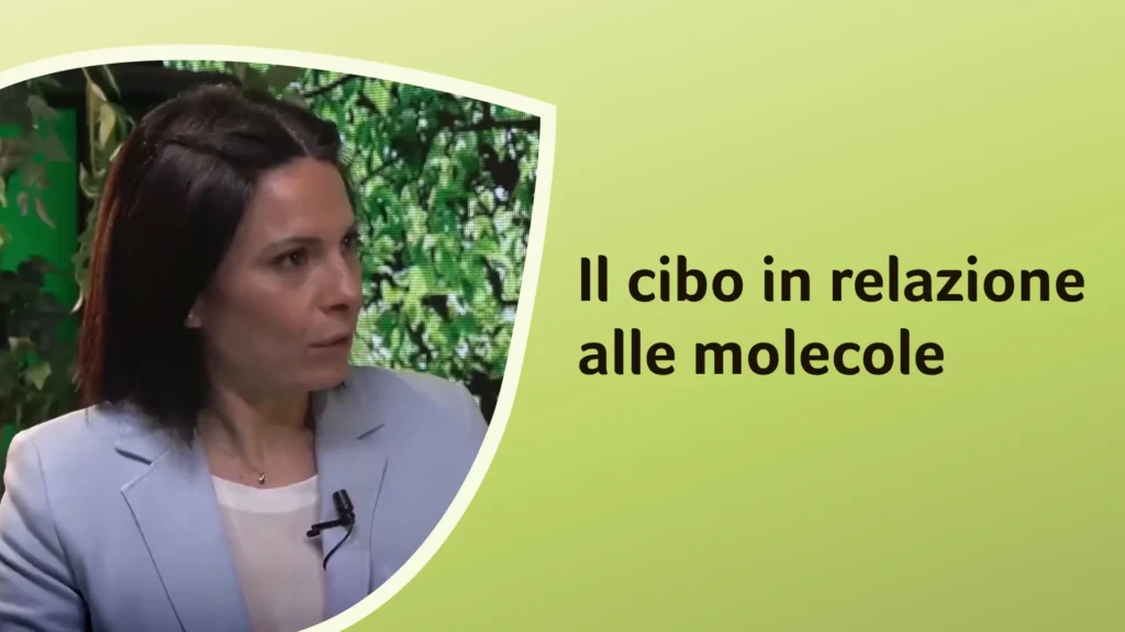 La dottoressa Ferrara ascolta con attenzione durante una conversazione su cibo e molecole. Sullo sfondo è riportato il titolo dell'episodio: “Il cibo in relazione alle molecole”.