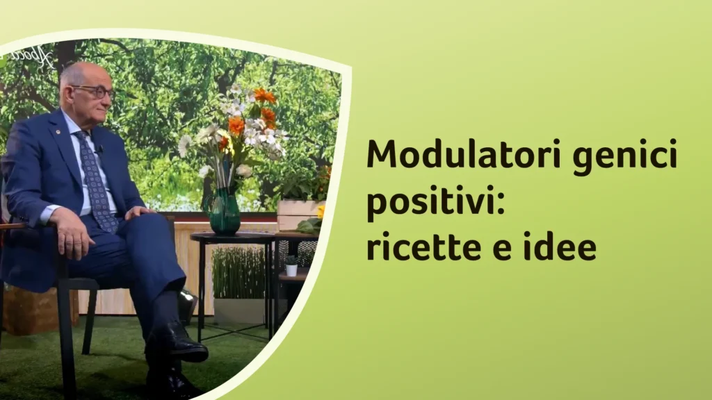 Il dottor Rossi seduto accanto a un tavolino con un vaso di fiori, in un ambiente che richiama la natura e la salute. Sullo sfondo è riportato il titolo dell'episodio: “Modulatori genici positivi: ricette e idee”.