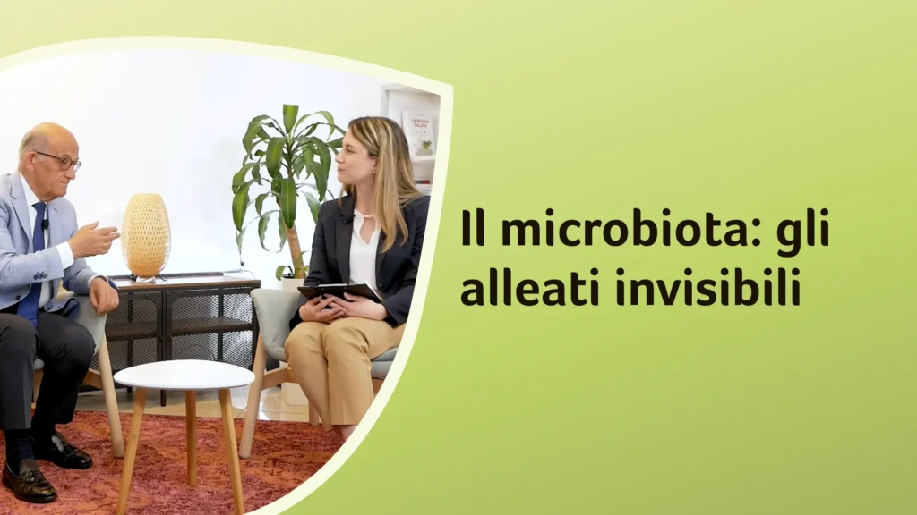Il dottor Rossi conversa con la dottoressa Freddoni in uno studio con una lampada e una pianta. Sullo sfondo è riportato il titolo dell'episodio "Il microbiota: gli alleati invisibili"